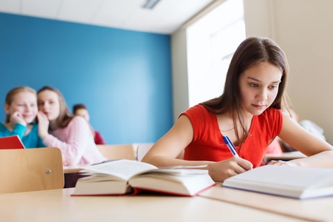 students gossiping behind classmate back at school