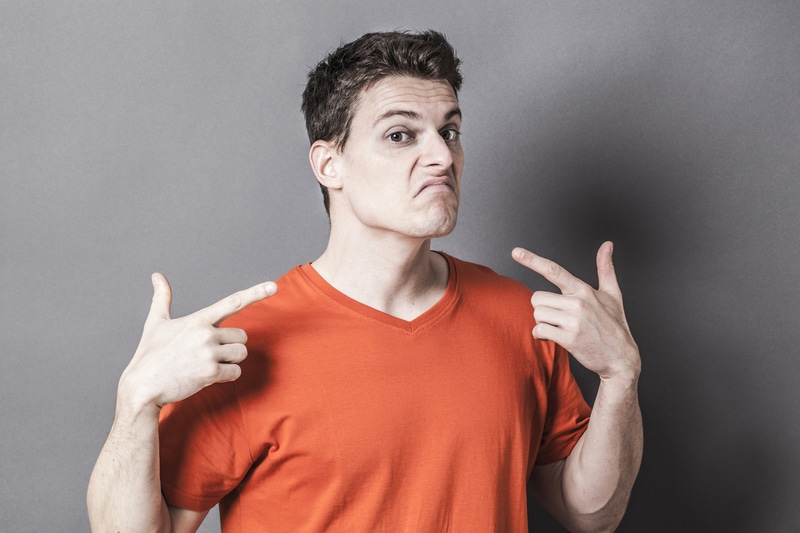 unhappy young sporty man showing throat with gun-like hands