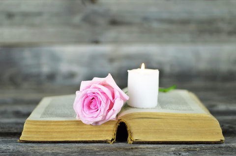 Sympathy card with burning candle and rose on open book