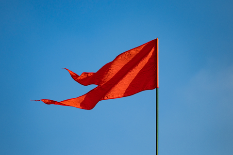Red flag waving on blue sky background