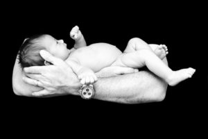 Newborn baby held in father's arms